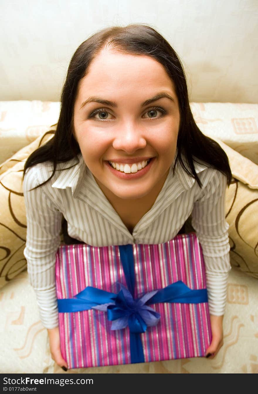 Funny girl holding a gift box with blue bow