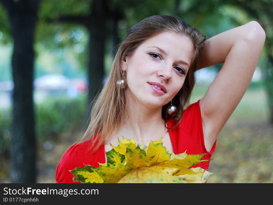 Young beautiful woman in red with yellow maple leaves. Young beautiful woman in red with yellow maple leaves