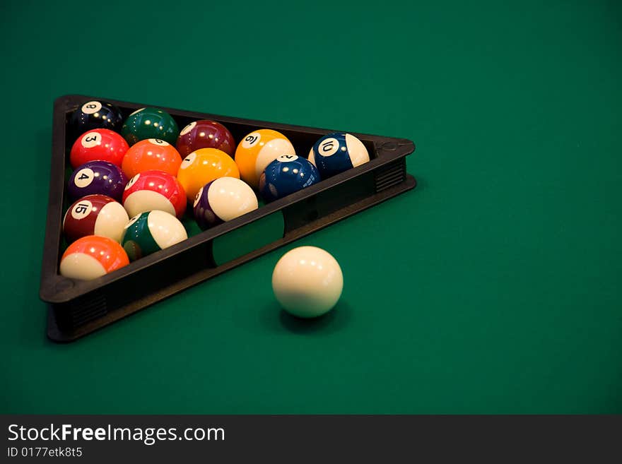 Color billiard balls on a green table in sport bar