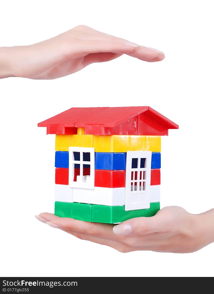 Toy colour plastic house with red roof in palms of young woman. Toy colour plastic house with red roof in palms of young woman