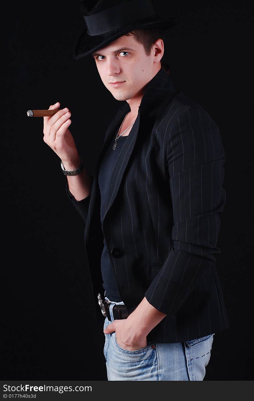 Portrait of young gangster in black suit with cigar. Portrait of young gangster in black suit with cigar