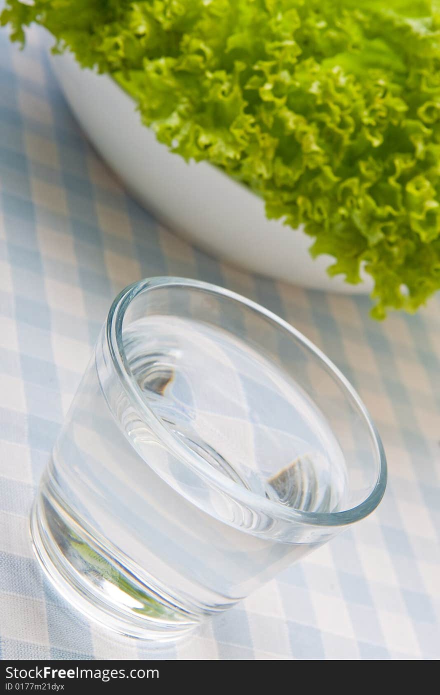 Bowl of lettuce and a glass of water. Bowl of lettuce and a glass of water