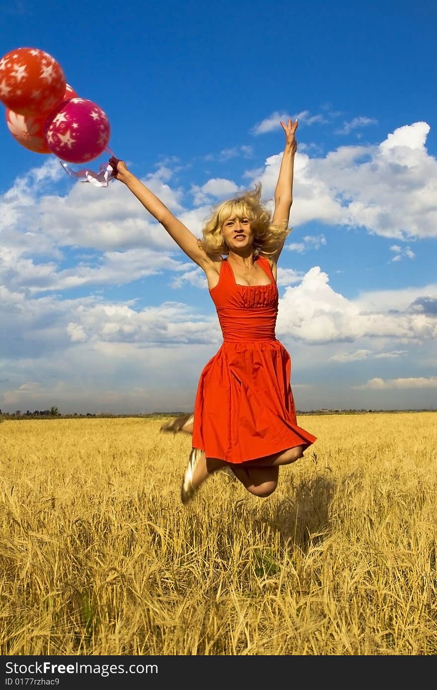 Lady in red jumping with balloons. Lady in red jumping with balloons