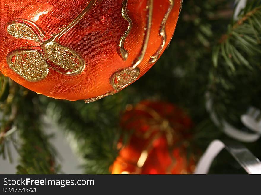 Gold Christmas ball and  paper streamer hanging from pine tree