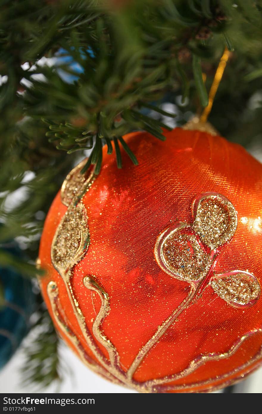 Gold Christmas ball and  paper streamer hanging from pine tree