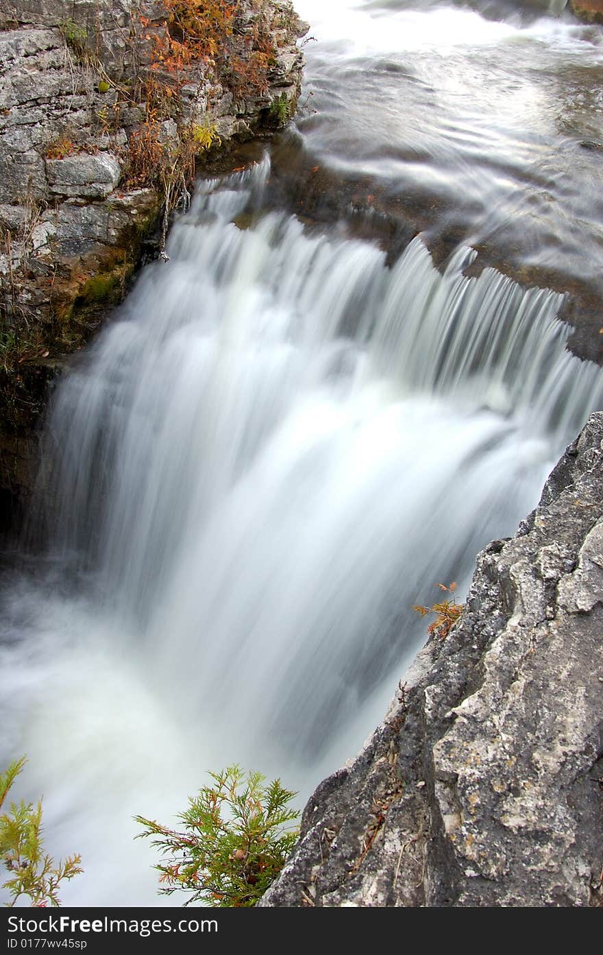 An image of a water falls flowing into a river. An image of a water falls flowing into a river.