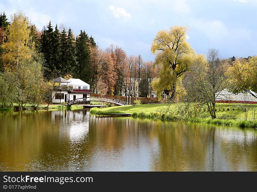 Beautiful lake with bridge in the autumn park