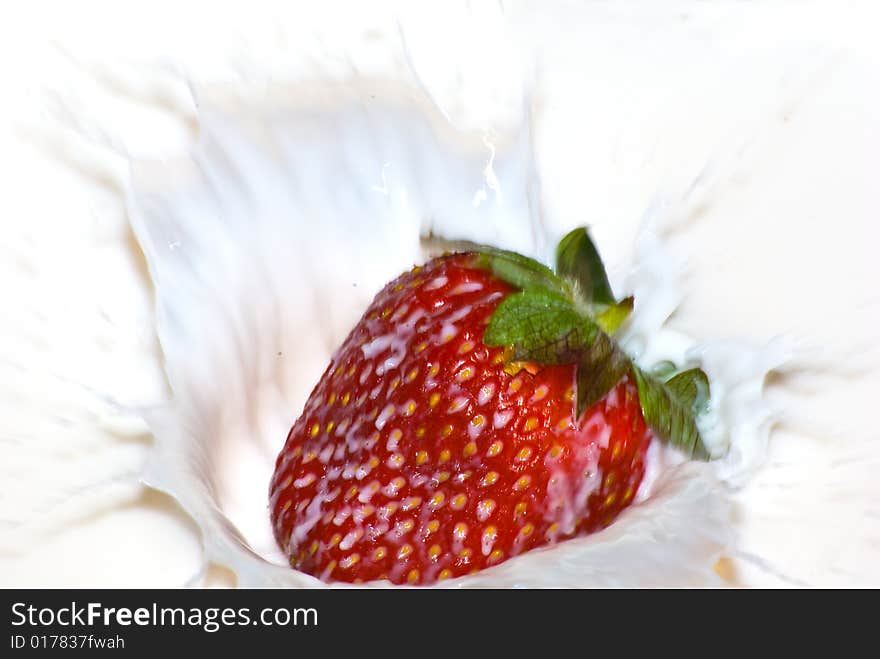 Motion of an strawberry dropped into milk causing splashes. This if drop in another angle. Motion of an strawberry dropped into milk causing splashes. This if drop in another angle.