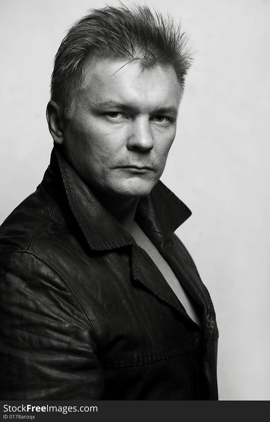 Model man in black leather jacket on gray background