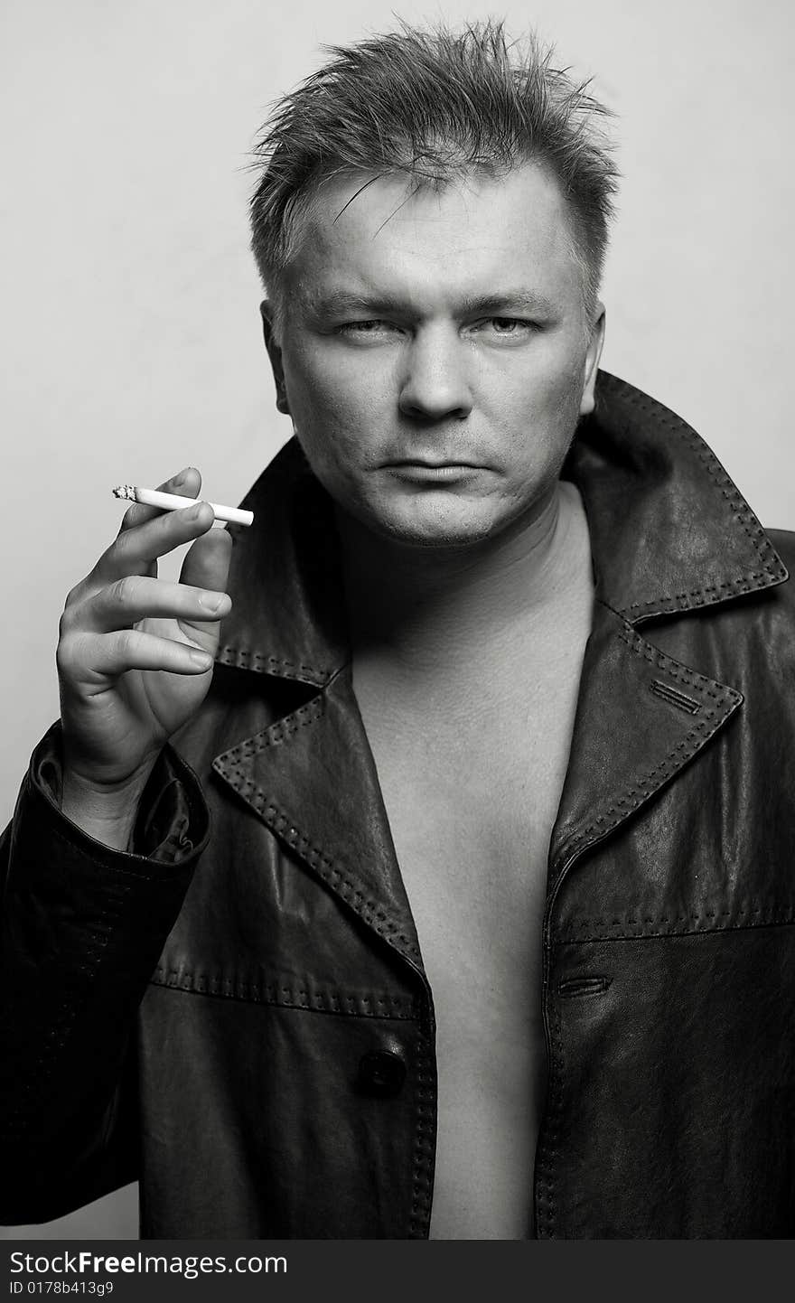 Model man in black leather jacket on gray background