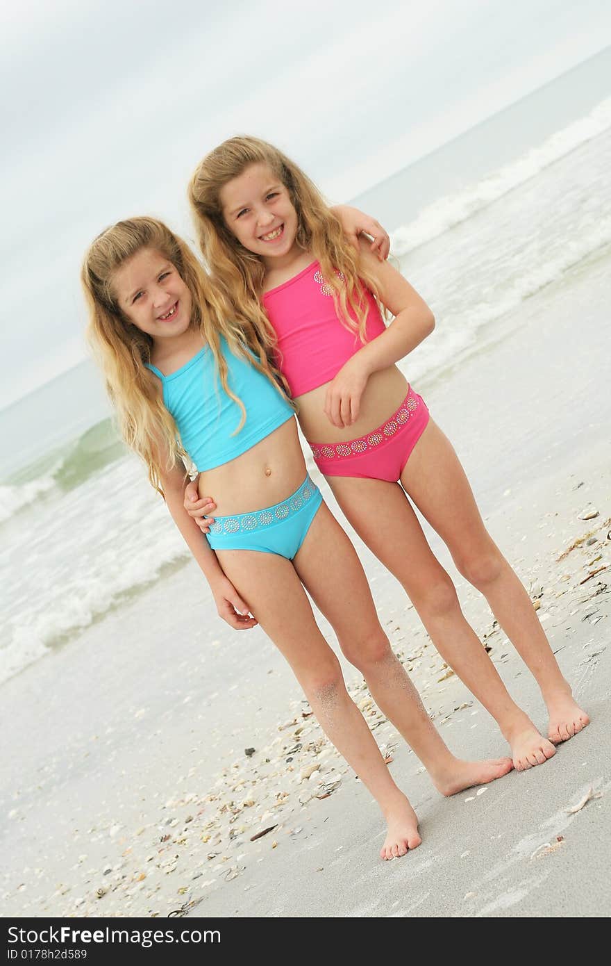 Twin sisters at the beach vertical angle