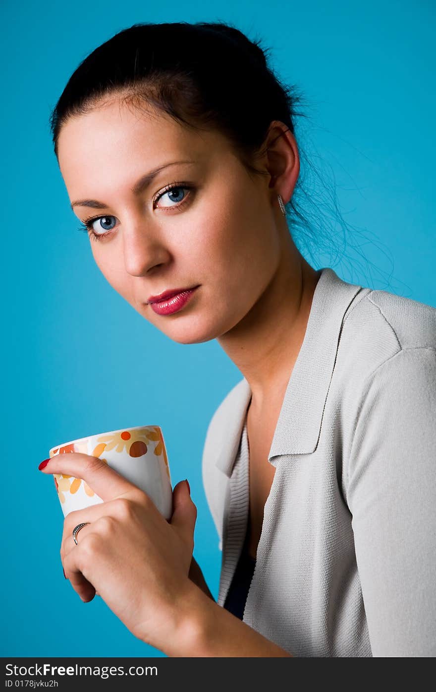 The beautiful brunette with a cup in hands. The beautiful brunette with a cup in hands