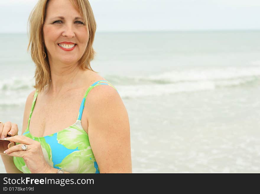 Woman at the beach drinking water vertical