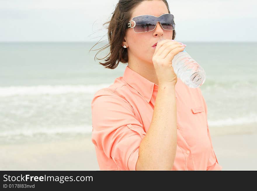 Shot of a beautiful brunette drinking water. Shot of a beautiful brunette drinking water