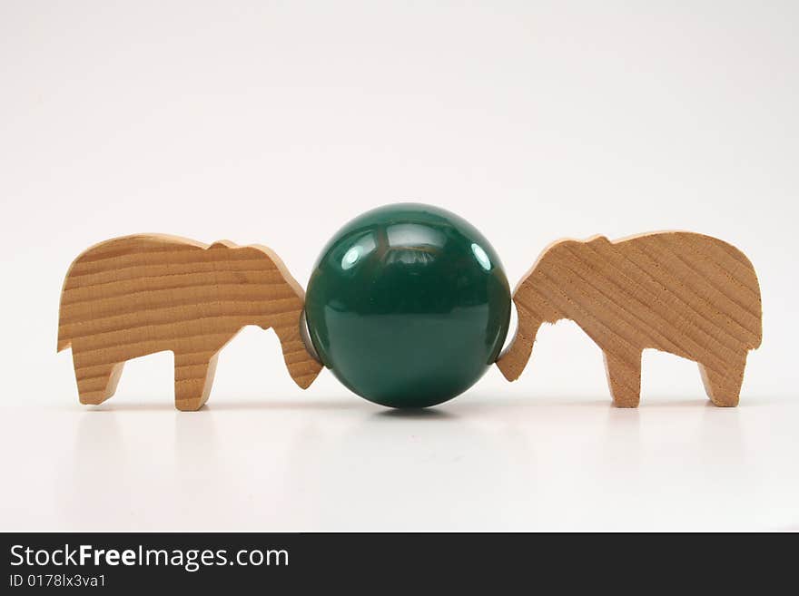 Wooden toys elephants push the ball on white