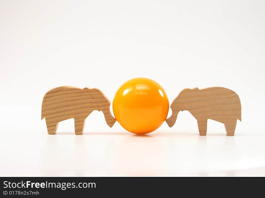 Wooden toys elephants push the ball on white