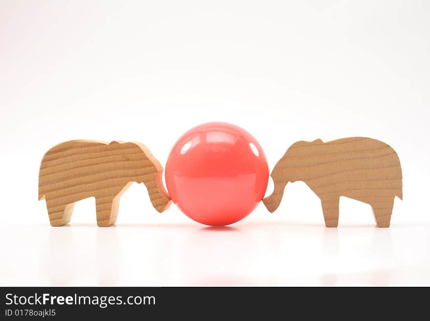 Wooden toys elephants push the ball on white