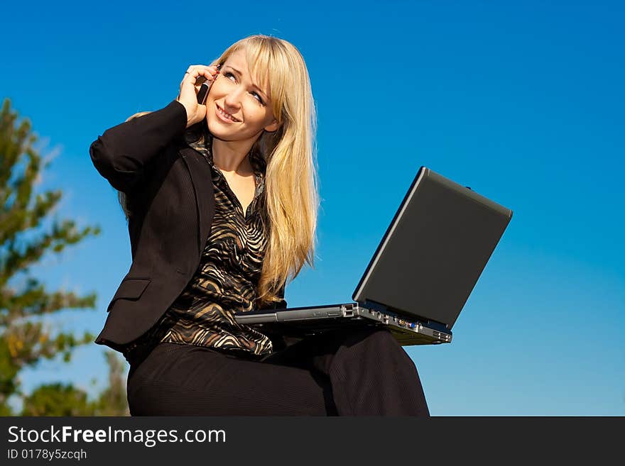 Woman with laptop talking on a phone