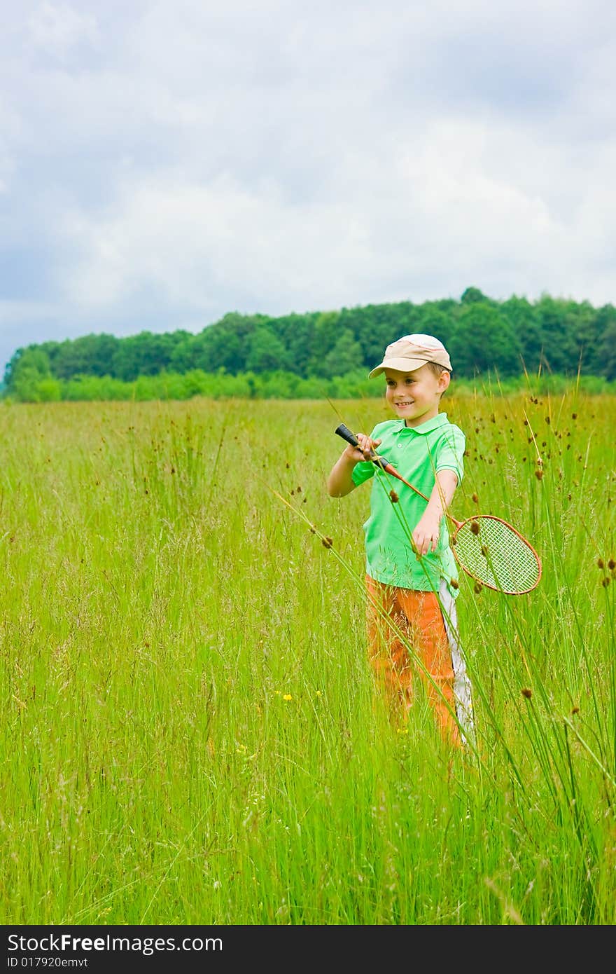 Cute kid playing badminton outdoors