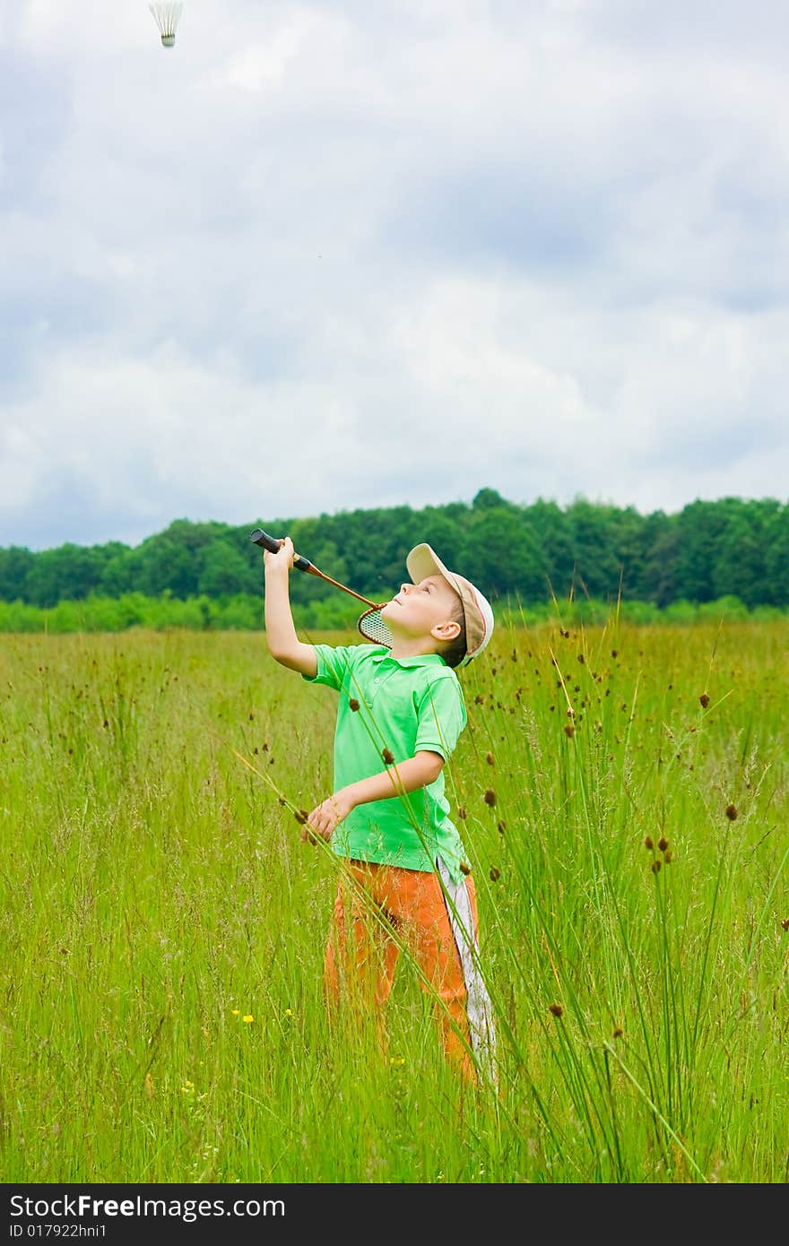 Cute kid playing badminton outdoors