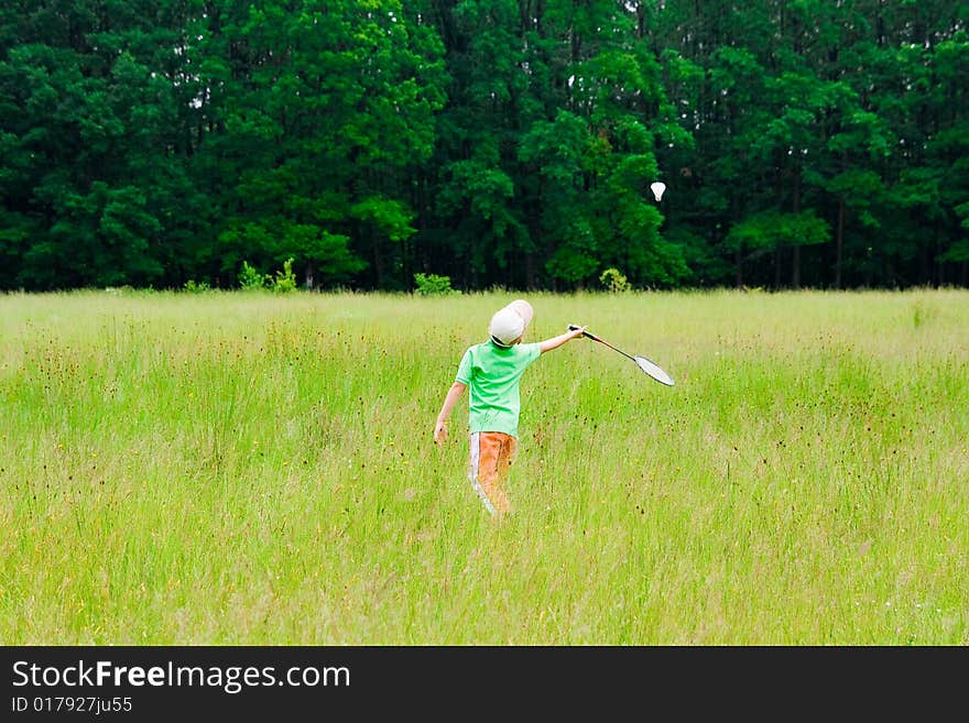 Cute kid playing badminton outdoors