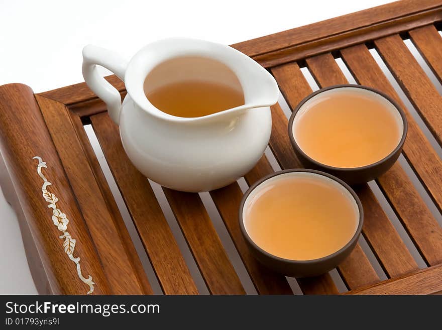 A tray for chinese tea ceremony with cups of tea and teapot isolated on white background. A tray for chinese tea ceremony with cups of tea and teapot isolated on white background