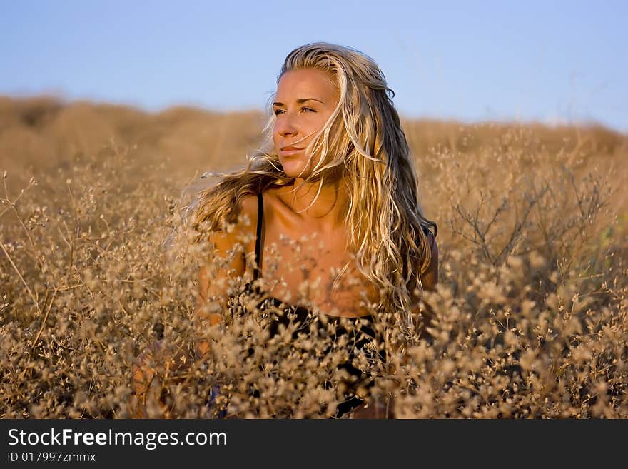 Girl sitting on straw grass in the valley. Girl sitting on straw grass in the valley