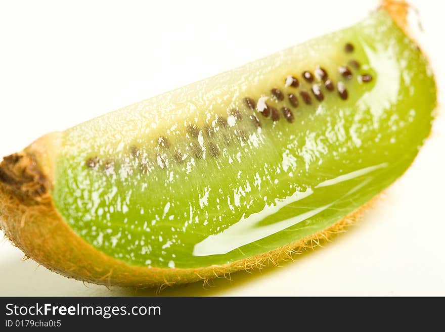 A single juicy kiwi quarter isolated against a white background. A single juicy kiwi quarter isolated against a white background.