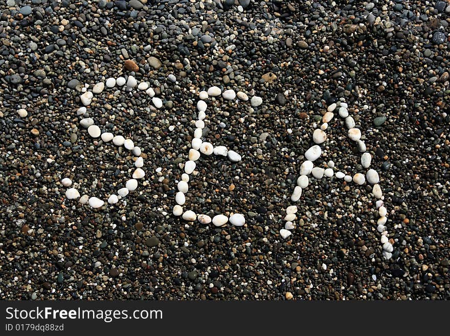 Sea word on the wet pebbles