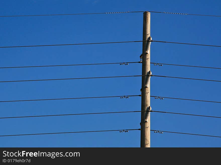 Power lines and pole against a pure blue sky.