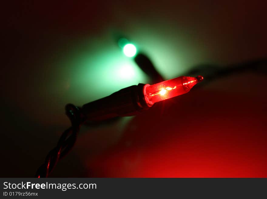 Red and green Christmas lights casting green and red hues on the background