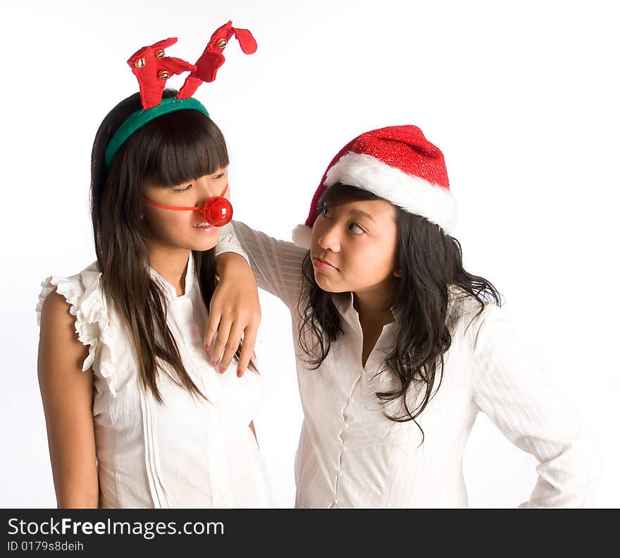 Girl friends in funny head wear gossiping at a Christmas party