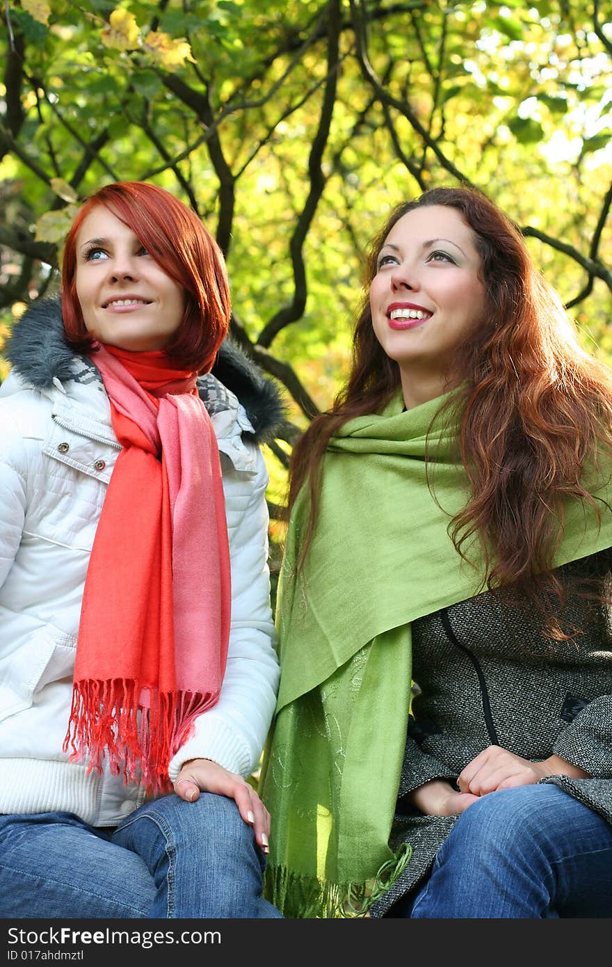 Two young girls relaxing in autumn park. Two young girls relaxing in autumn park