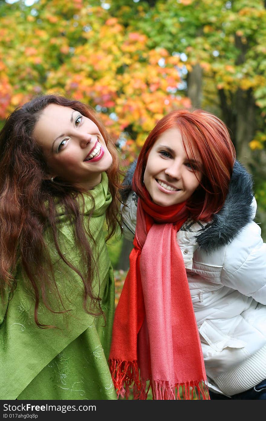 Two young girls relaxing in autumn park