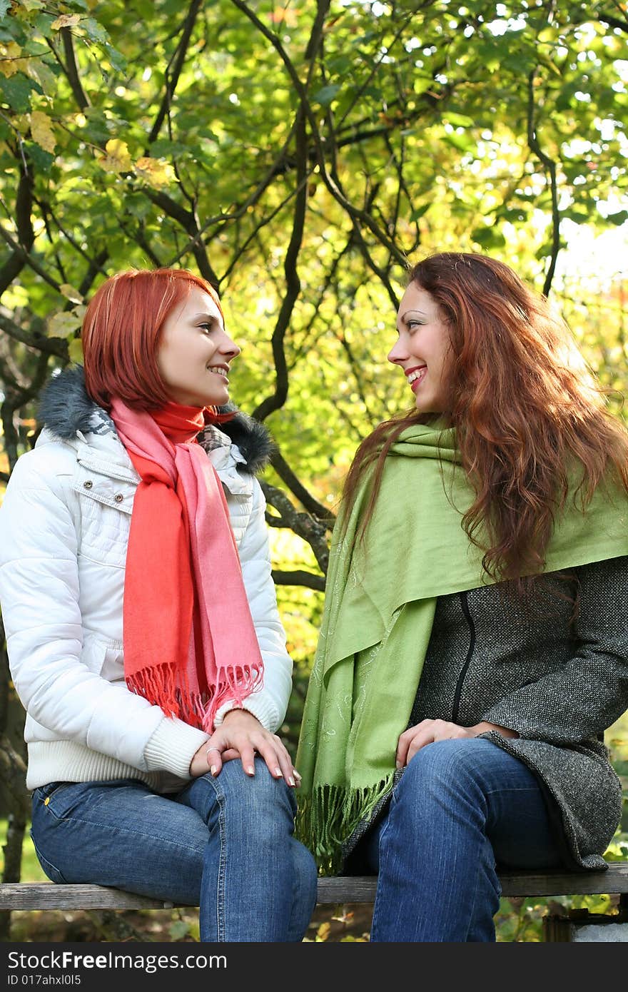 Two young girls relaxing in autumn park. Two young girls relaxing in autumn park