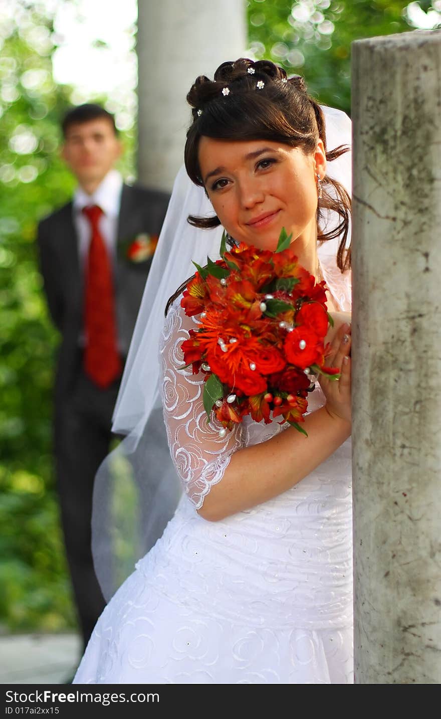 Bride near the column. Out of focus fiance