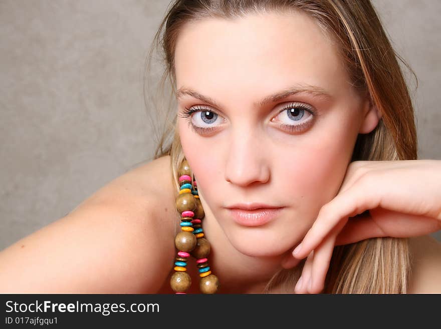 Beautiful female model with blue eyes and a string beads