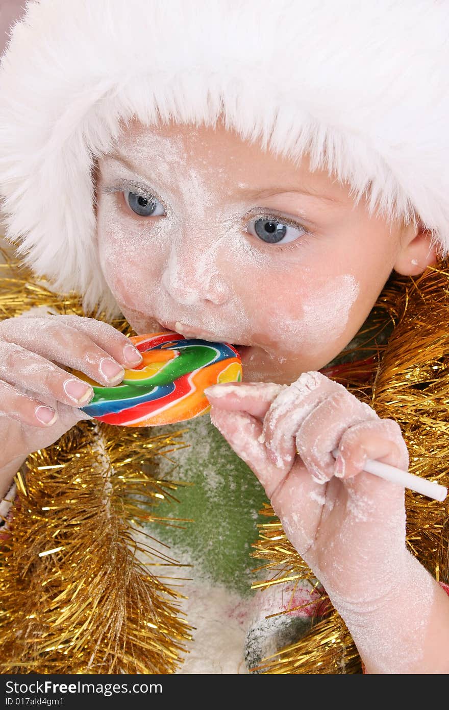 Christmas toddler got a lollipop reward for baking cookies. Christmas toddler got a lollipop reward for baking cookies