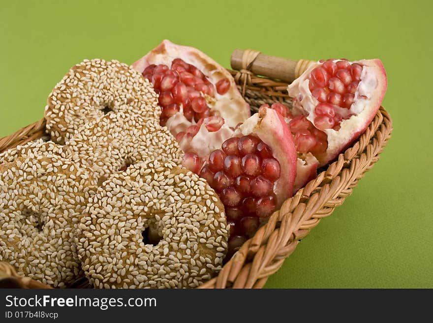 Pomegranate close-up in basket isolated on green background