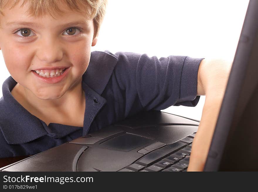 Happy little boy checking emails on computer