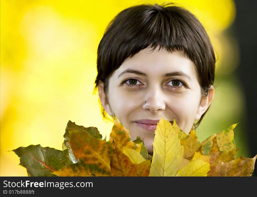 Young woman with maple leaves in hand