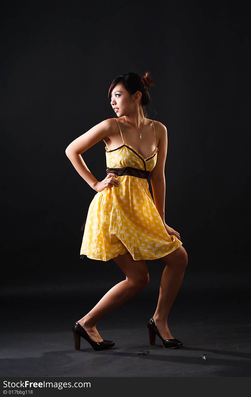 Playful asian girl in yellow polka dot dress. Playful asian girl in yellow polka dot dress