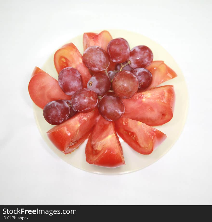 A small bowl of fruit and tomatoes. A small bowl of fruit and tomatoes