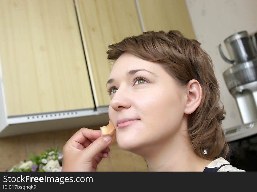 A cosmetologist applies face make-up for a girl