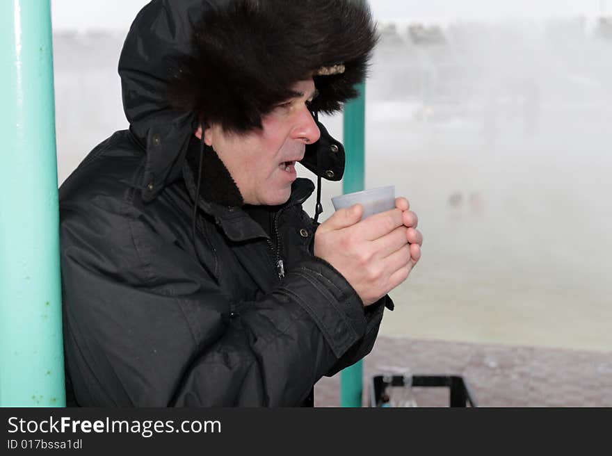 The man drinks a hot tea in winter. The man drinks a hot tea in winter