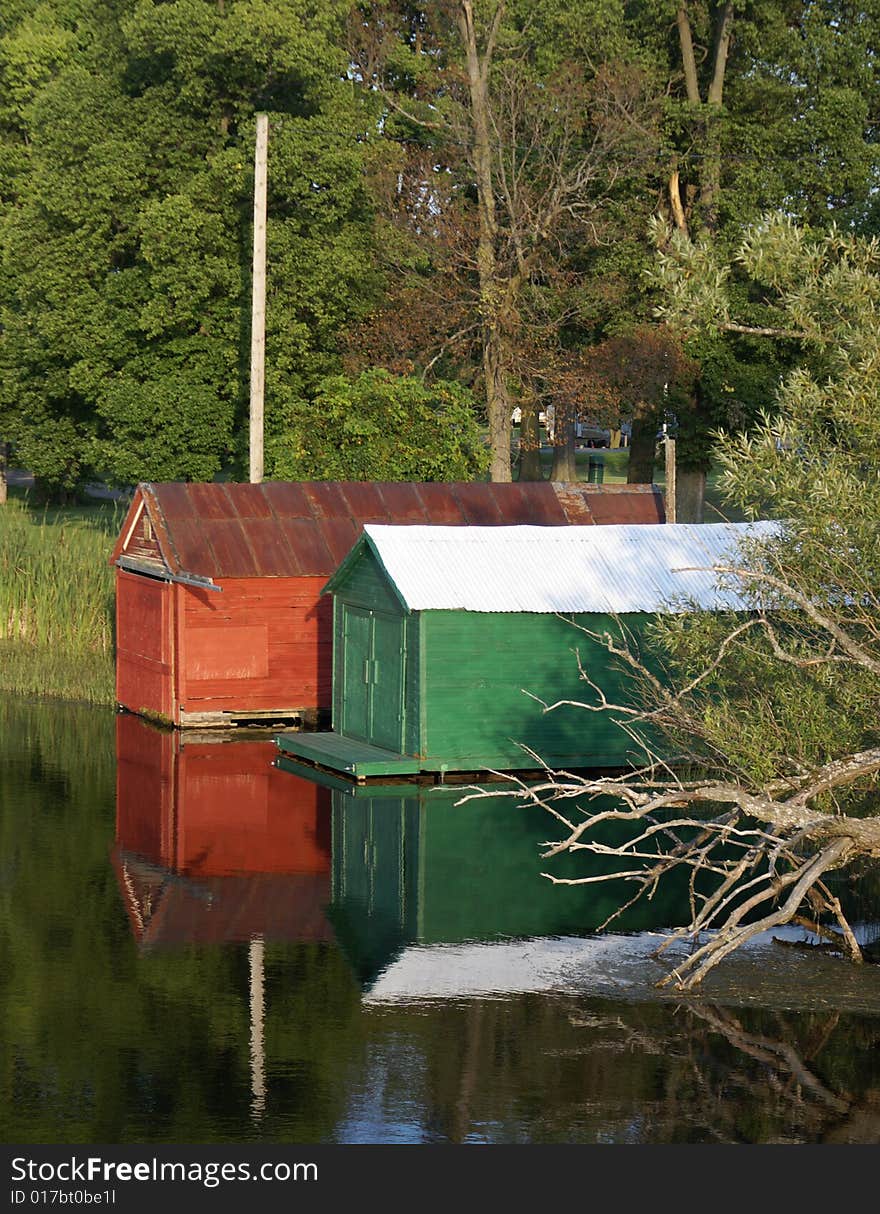 A pair of boathouses on the river. A pair of boathouses on the river.