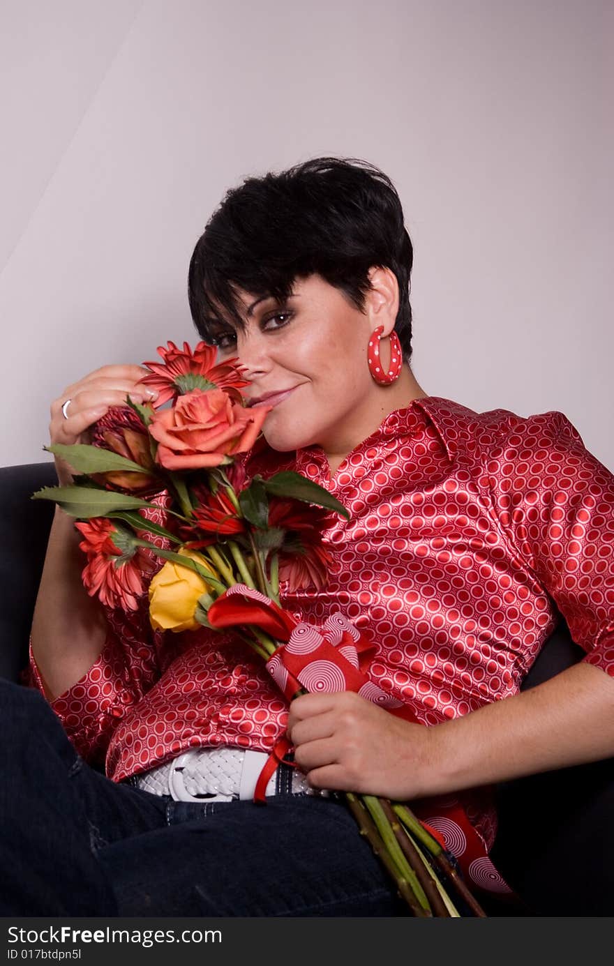 A beautiful, friendly woman holing flowers smiling at the camera. A beautiful, friendly woman holing flowers smiling at the camera.