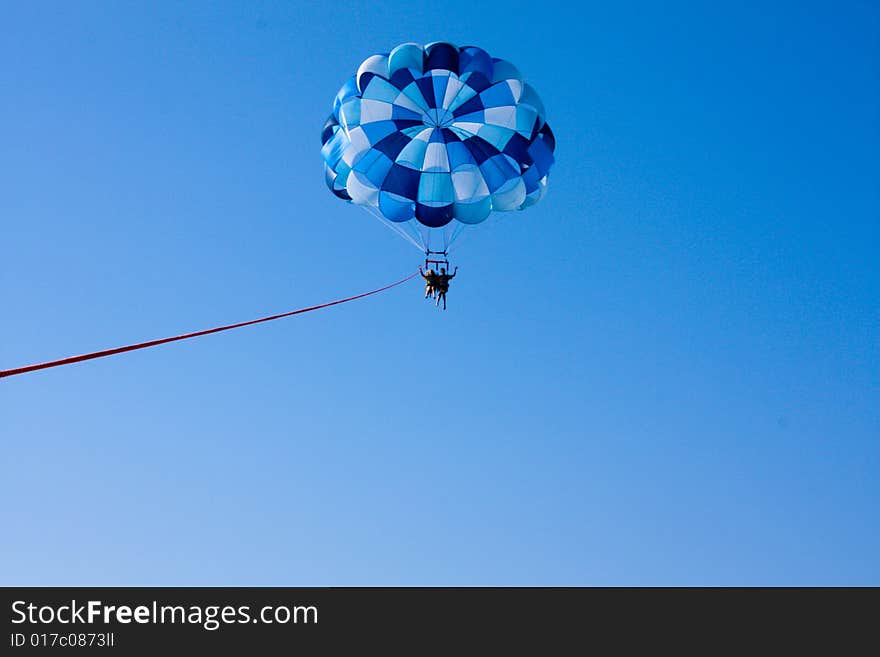 Two people parasailing over the ocean. Two people parasailing over the ocean