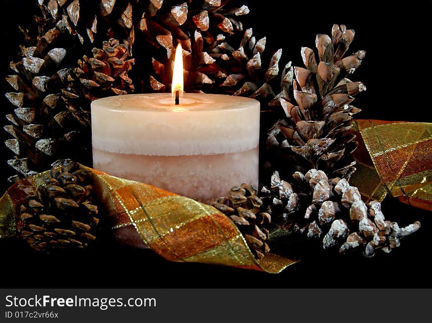 Flickering candle in pine cones and ribbon. Flickering candle in pine cones and ribbon.