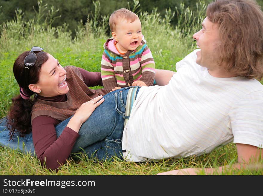 Parents with baby lies on nature